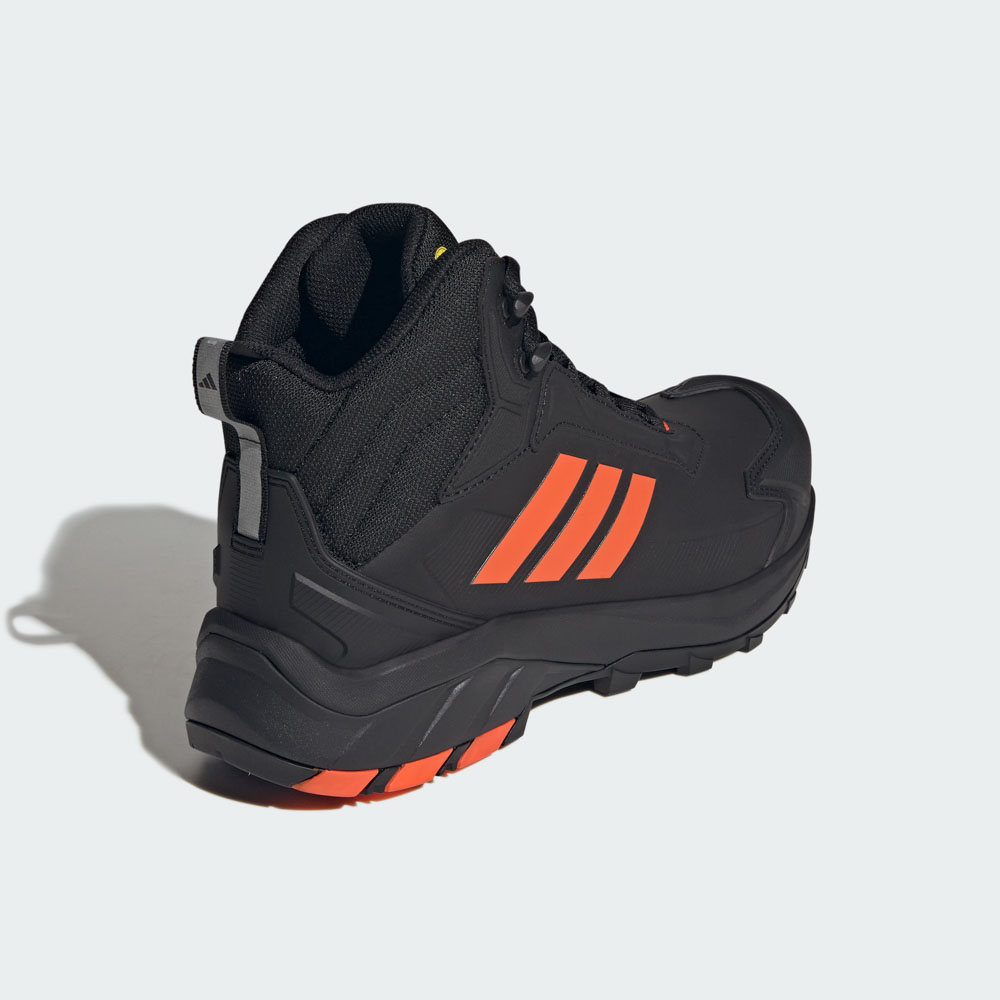 Schwarzer adidas Terrex Outdoor-Boot mit orangefarbenen 3-Streifen und robuster Profilsohle, Ansicht von hinten