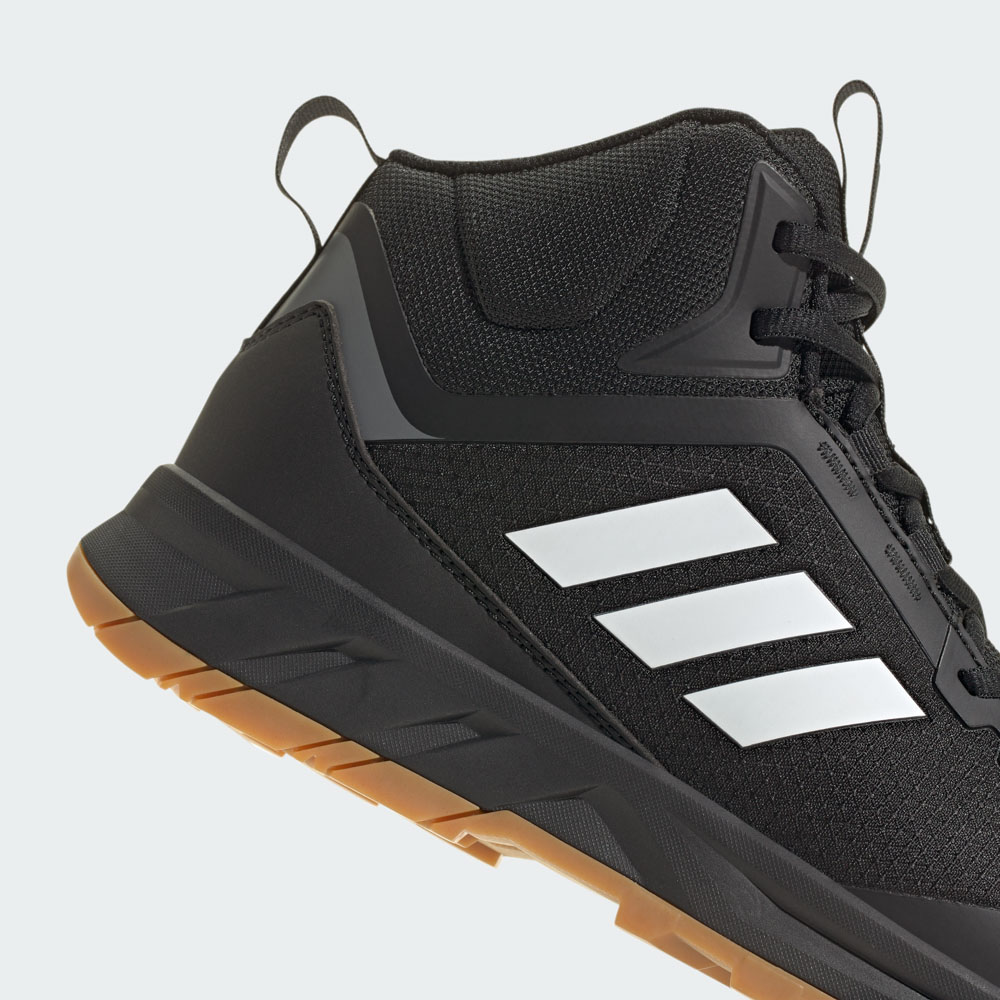 Detailansicht eines schwarzen adidas Sneakers mit den drei weißen Streifen und robuster Gummisohle im Braunton