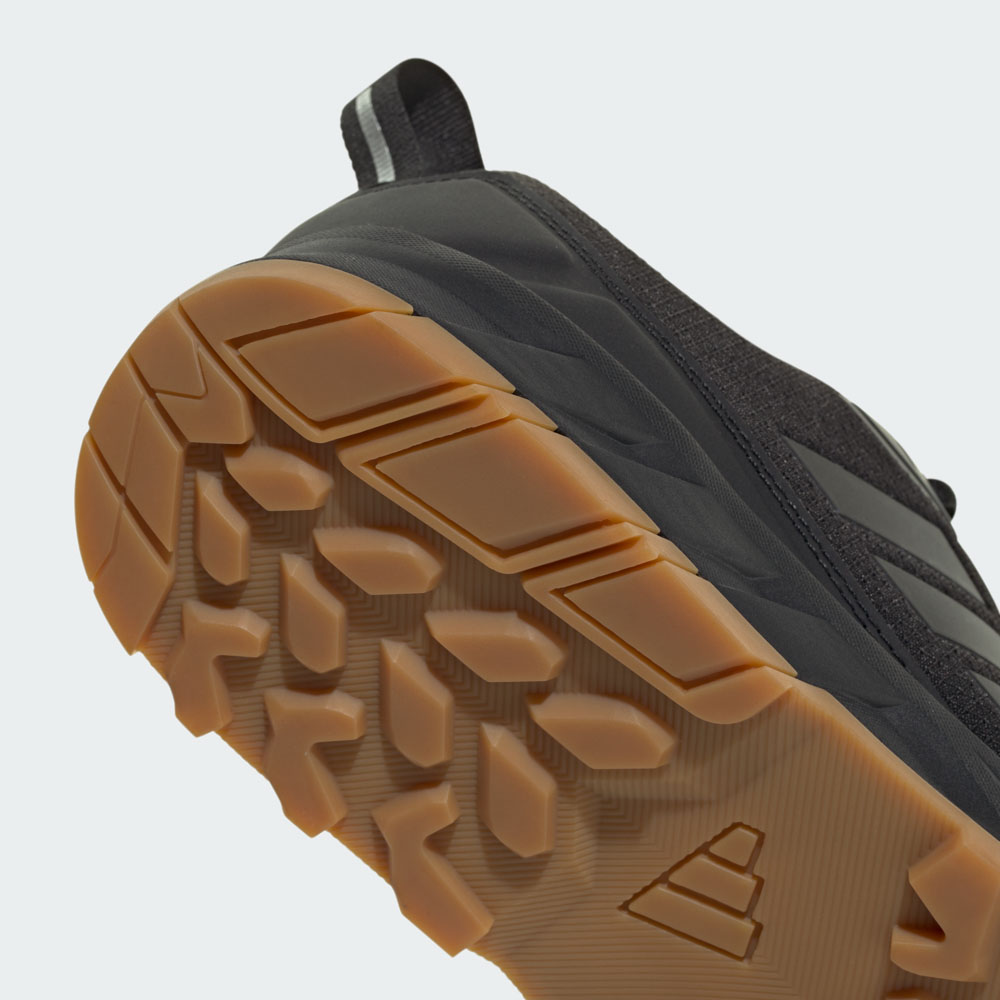 Nahaufnahme der robusten Gummi-Außensohle eines schwarzen adidas Outdoor-Schuhs mit tiefem Profil für optimalen Grip