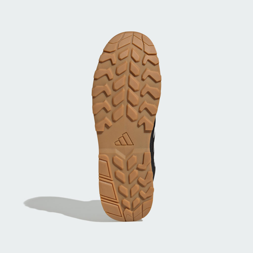 Unteransicht eines adidas Outdoor-Schuhs mit robuster Gummisohle und tiefem Profil für optimale Traktion
